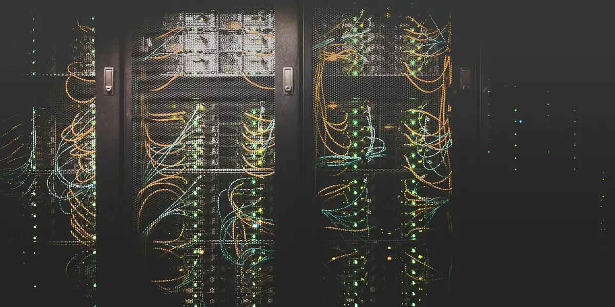 Racks de servidores iluminados en una sala de alojamiento web